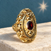 Anello Marquise Rosso chiuso su pietra chiara, con cristallo ovale e montatura bicolore.