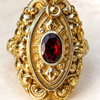 Dettaglio del cristallo rosso ovale e delle volute in metallo bicolore di Marquise.