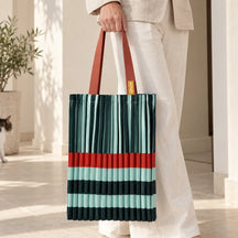 Tote verde e acqua portata in mano, con fascia arancio e manici color ruggine visibili.