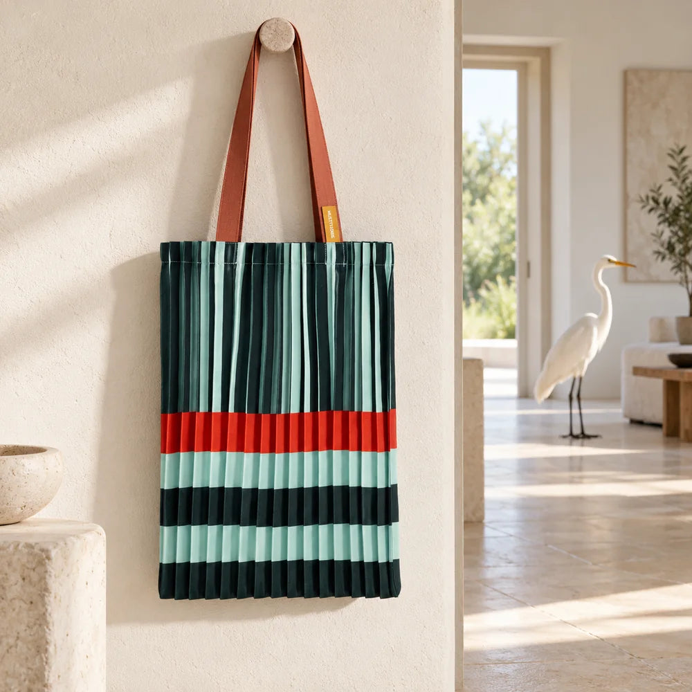 Tote verde e acqua in una galleria luminosa, con un airone bianco nella stanza sullo sfondo.