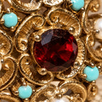Dettaglio della pietra rossa centrale e delle volute dorate dell’anello d’Este.
