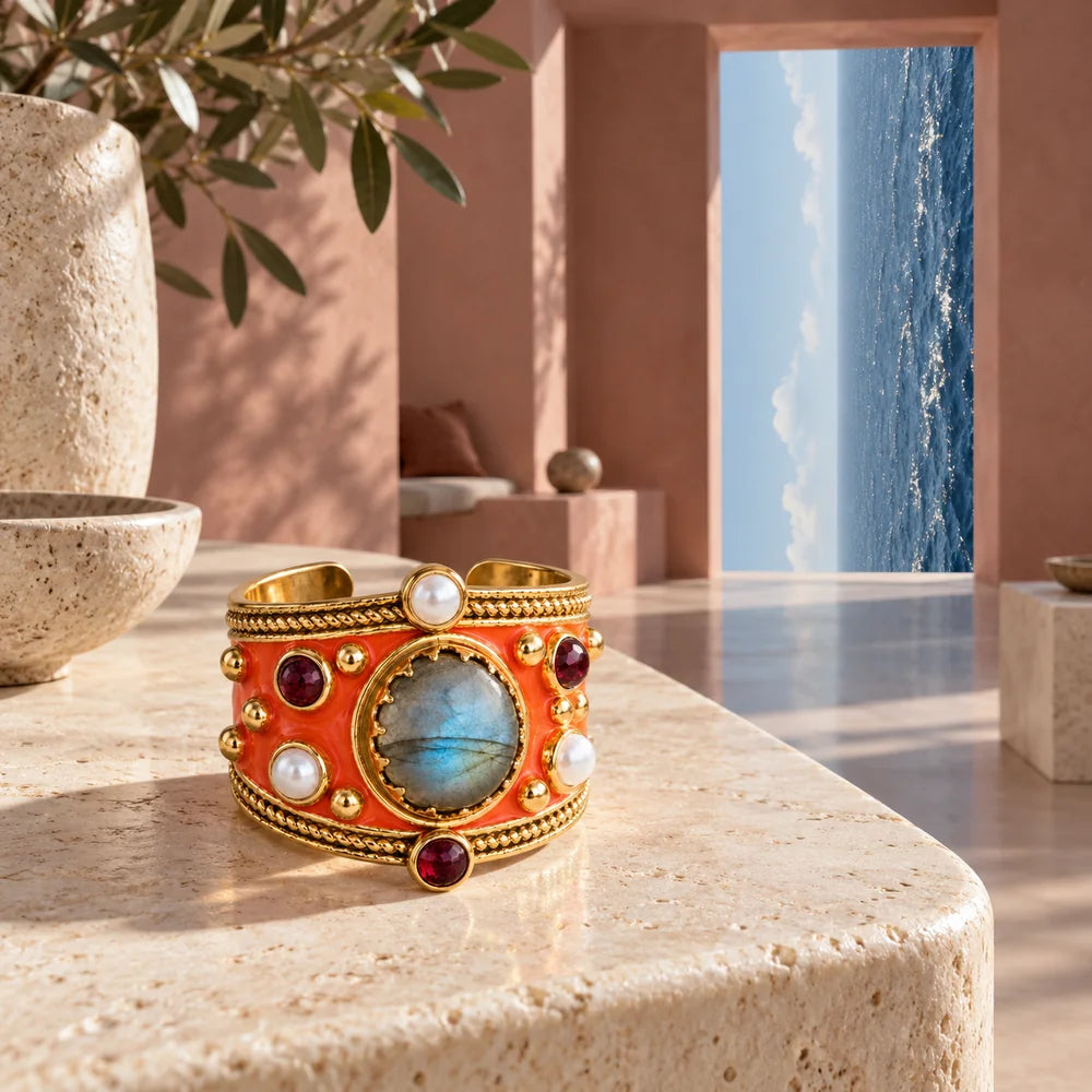 Alhambra Arancio su una console avorio; sul fondo un’apertura mostra il mare con l’orizzonte verticale.