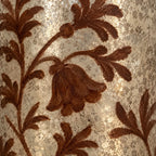Dettaglio del motivo floreale dipinto color ruggine sulla superficie argentata del vaso.