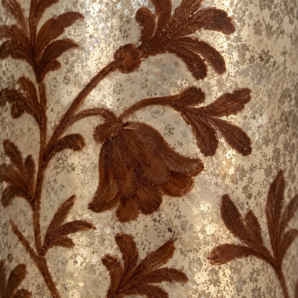 Dettaglio del motivo floreale dipinto color ruggine sulla superficie argentata del vaso.