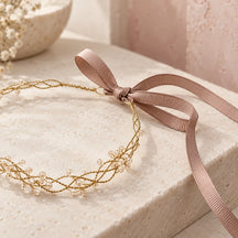 Dettaglio del fiocco in grosgrain tortora e della chiusura regolabile della coroncina arancio.