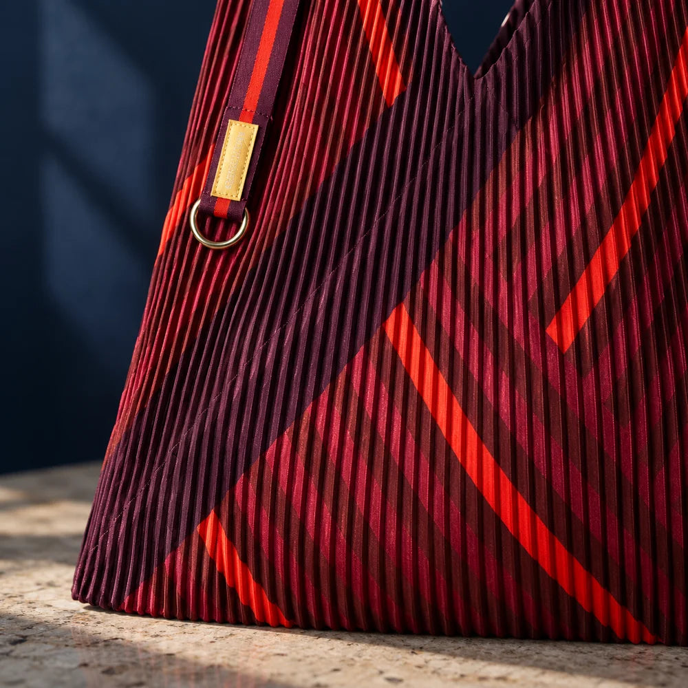 Dettaglio del plissé e delle geometrie rosse e bordeaux della borsa Granata.