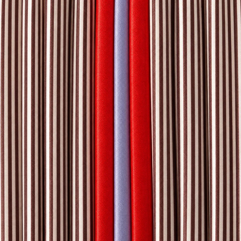Dettaglio delle righe marrone e crema, della striscia rossa e del plissé della tote.