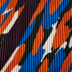 Dettaglio del camouflage arancio, blu, verde scuro e crema sul tessuto plissettato.