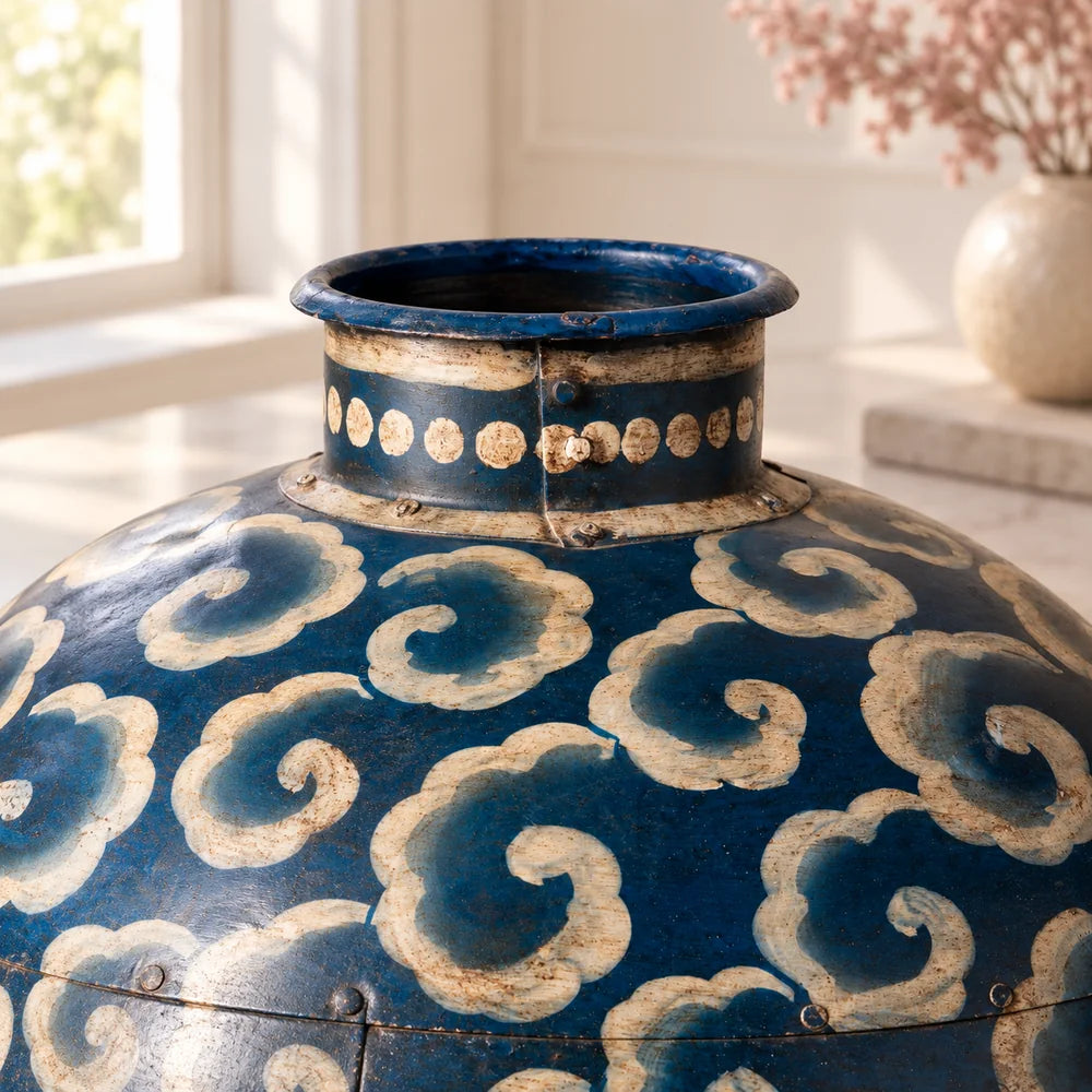 Dettaglio del collo aperto, del bordo e dei puntini beige del vaso decorativo blu in ferro.