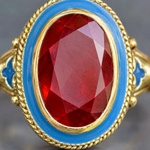 Dettaglio del granato rosso sfaccettato, del bordo dorato e dello smalto blu di Persia.