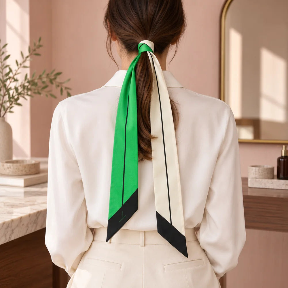 Twilly verde smeraldo e bianco annodato ai capelli raccolti, con le due punte nere visibili.
