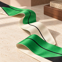 Dettaglio della seta double face verde smeraldo e bianco e della linea nera del Twilly.