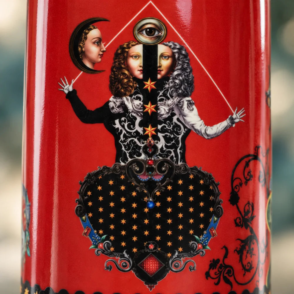 Dettaglio del decoro della candela Europa Orientale: figura doppia, occhio e costume bianco e nero sul fondo rosso.
