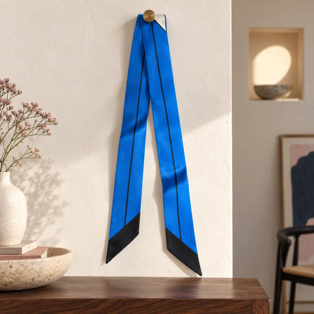 Twilly Blu e Bianco in seta, sostenuto da un piolo visibile, con il lato blu, la linea nera e le punte oblique intere.