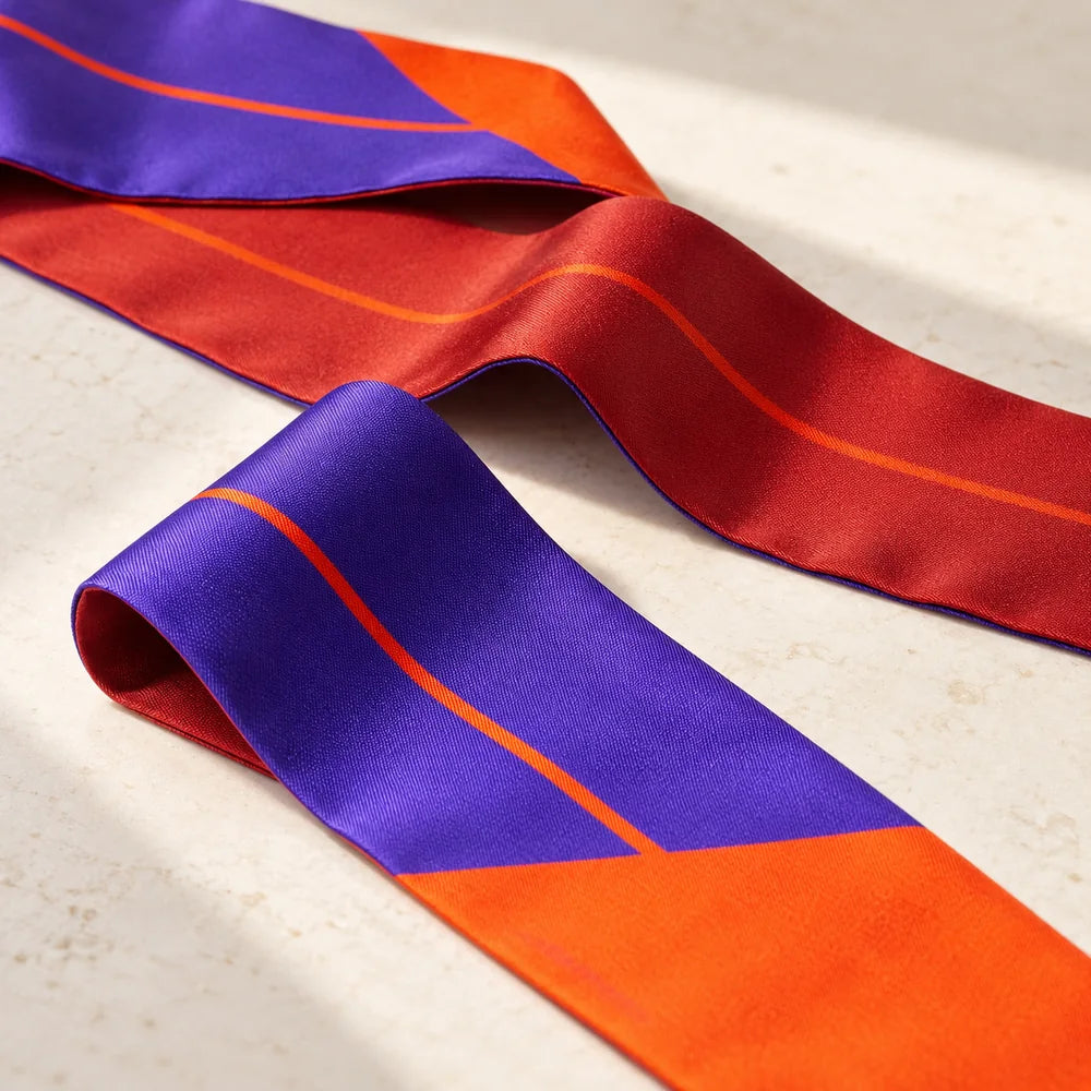 Dettaglio della seta double face viola e bordeaux e della sottile linea arancio del Twilly.