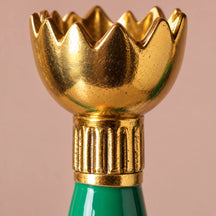 Dettaglio della coppa dorata a tulipano e del collare rigato del candelabro Retro.