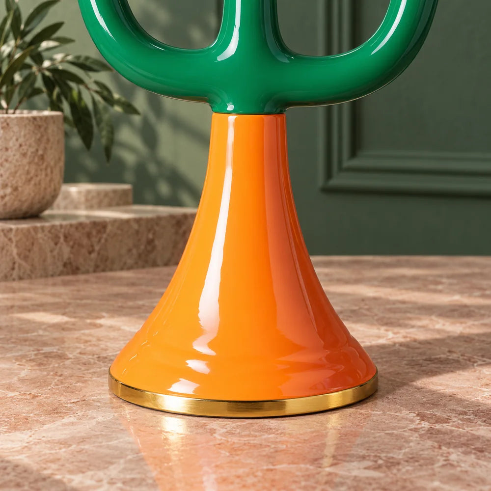 Dettaglio del piede arancione svasato e del bordo dorato del candelabro Retro.