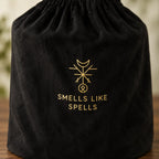 Dettaglio della sacca nera originale con simbolo dorato e scritta Smells Like Spells della candela Estremo Oriente.