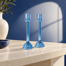 Set Soffio di due portacandele in vetro azzurro, senza candele, su un piano avorio.