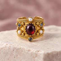 Dettaglio della pietra rosso scuro, delle perle e della fascia dell’anello Alhambra Effetto Oro.
