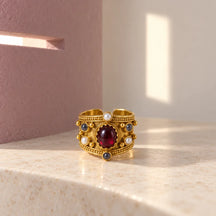 Anello Alhambra Effetto Oro in ambiente astratto con luce geometrica sulla parete.